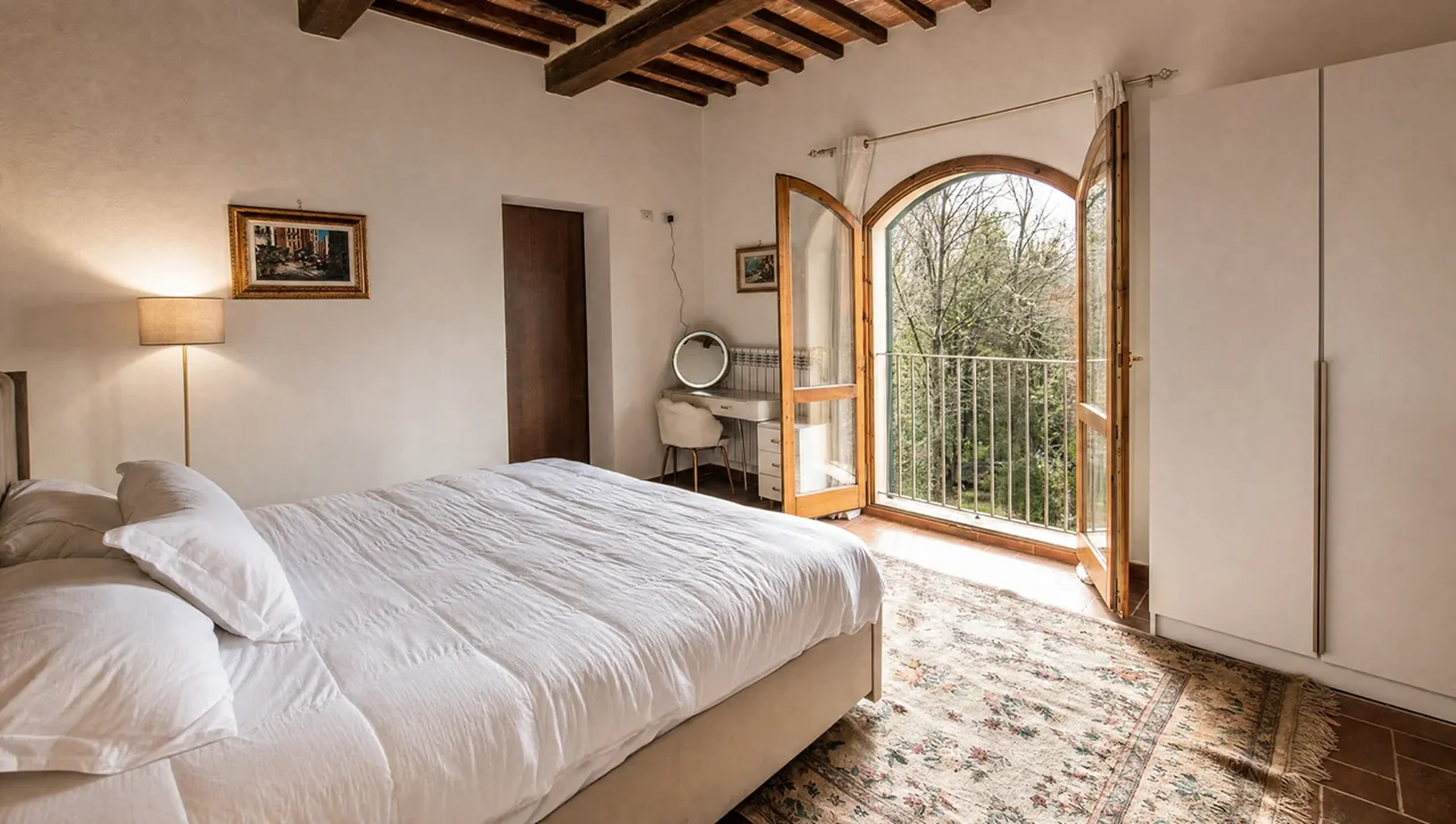 A bedroom with an arched door opening onto the valley