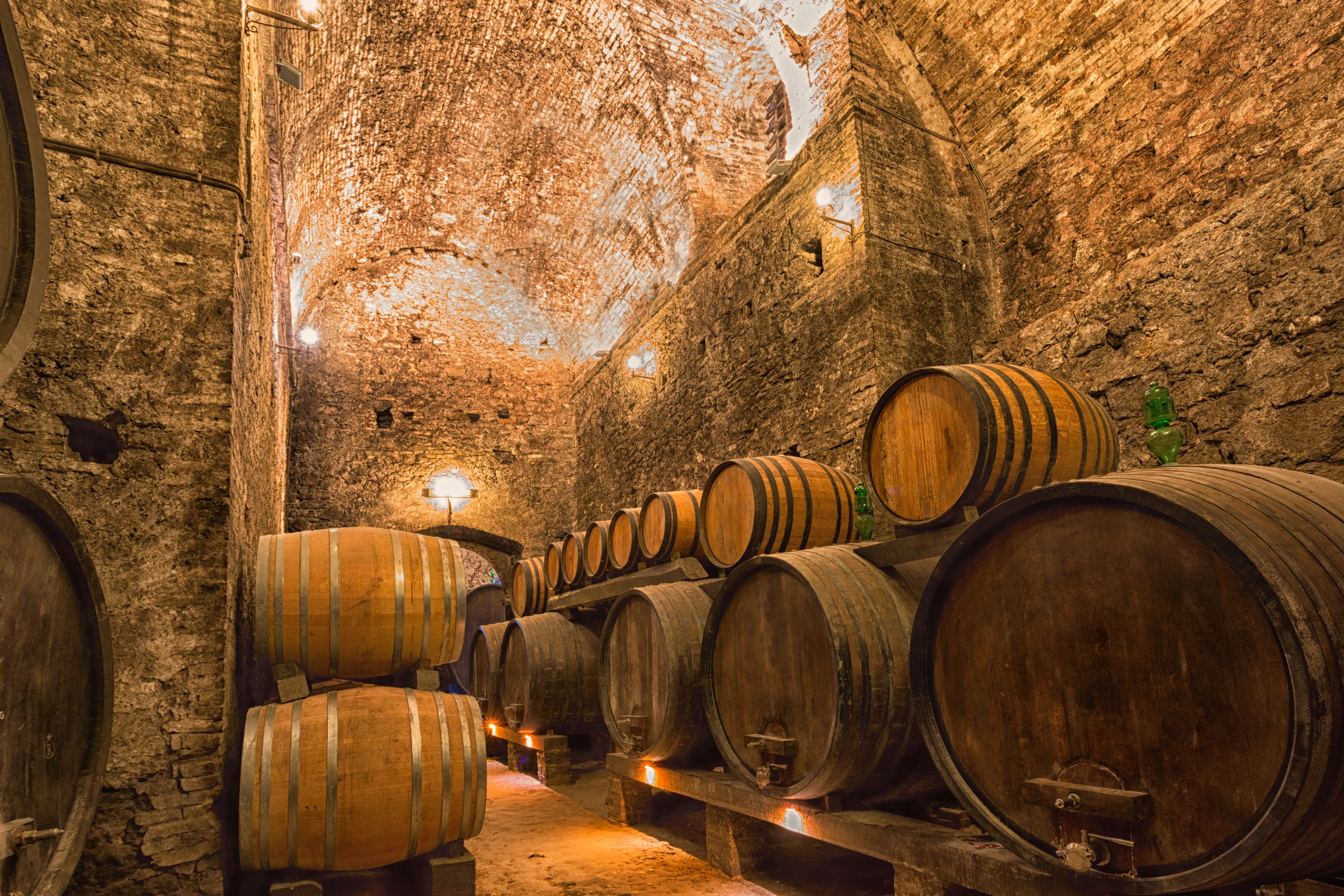 Rows of aging barrels in a Tuscan wine cellar